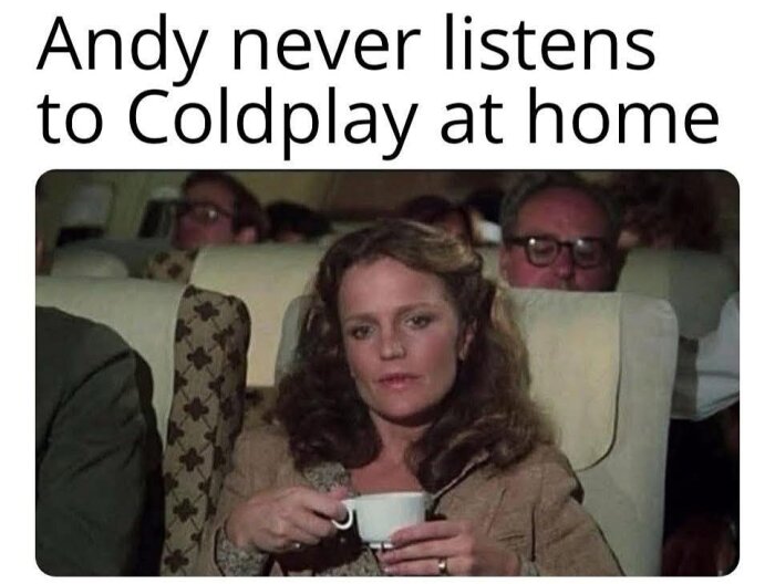 En kvinna sitter på ett flygplan och håller i en kopp, med texten "Andy never listens to Coldplay at home" ovanför.