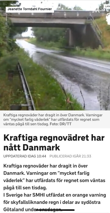 En viadukt med en väg nedanför som är delvis översvämmad efter kraftigt regnväder.