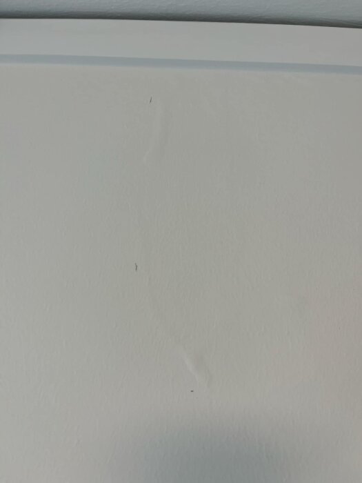 Bubblig färg på stenvägg inomhus, eventuellt orsakat av vattenläckage från taket, 1 meter från ett takfönster i ett Fiskarhedenvillan-hus.