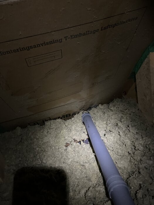 Rör i en vind med isolering och monteringsanvisning på väggen, inspekterade för tecken på läckage efter regn.