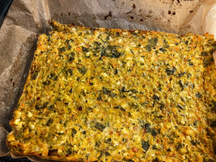Ugnsbakad grönsaksmix med morot, purjolök, zucchini, chili, persilja, grönkål och fetaost på bakplåtspapper.