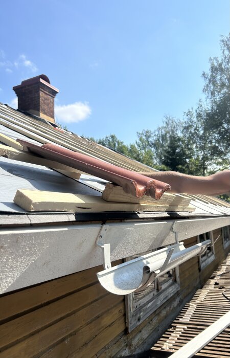 Tak med korta rännkrokar och hängränna, avståndet från takpannans droppkant till ytterkant av hängrännan är cirka 15 cm, problem vid installation.