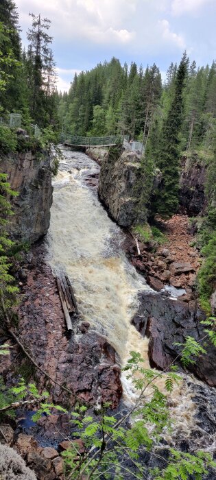 Vattenfall i en skogsklyfta nära Orsa med forsande vatten och trädklädda klippor runt omkring.