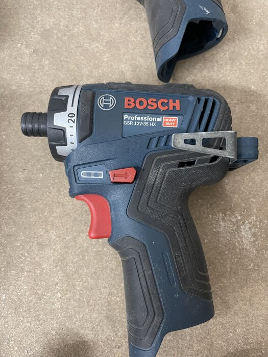 En Bosch 12V Professional GSR 12V-35 HX skruvdragare med röd och svart design visas på en bordsyta.