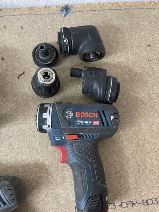 Bosch 12V borrskruvdragare med flera huvuden och tillbehör på en träyta.