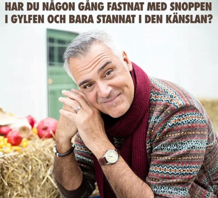 En medelålders man i färgglad tröja och halsduk ler mot kameran. Text ovan: "Har du någonsin fastnat med snoppen i gylfen och bara stannat i den känslan?