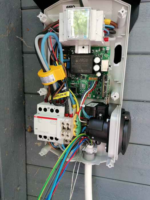 Invändig bild av en Garo laddbox med kretskort, kablar och en kontaktor nere till vänster, visande detaljkomponenterna.