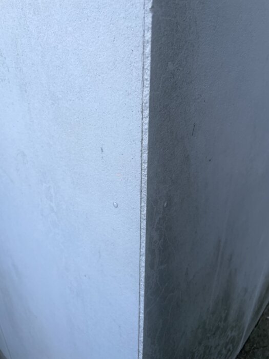 Närbild av vita och gråa skivor med slät yta, eventuellt eternitskivor.