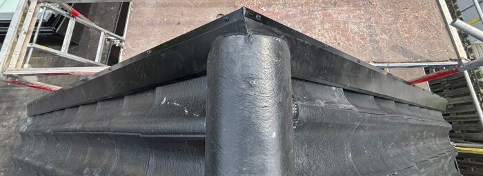 Taknock med svarta takpannor och byggställning runt, som någon annan gjort enligt forumdiskussion.