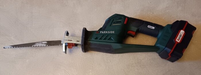 Batteridriven såg från Parkside med grön och svart design, lämplig för mindre träarbeten.