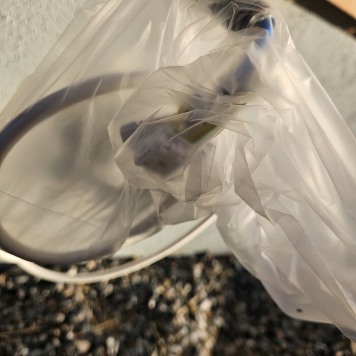 Luftvärmepumpens eluttag hängt på utsidan med plastskydd, risk för fukt.