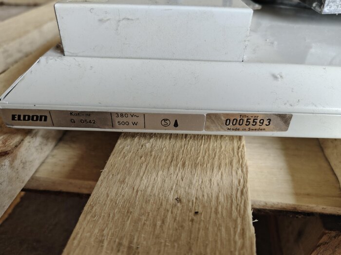 Gammalt elelement med etikett som visar "ELDON", 380 V och 500 W, stående på träyta. Fråga om återvinning eller annan användning av element.