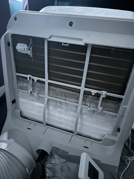 Frostig insida av en Midea AC-enhet med isbildning på kondensorn, eventuellt relaterat till kylmedels- eller fuktighetsproblem.