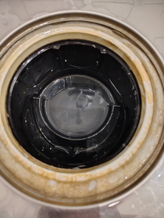 Närbild av en golvbrunns botten med synliga plast- och gummikomponenter efter att vattenlåset har tagits bort.
