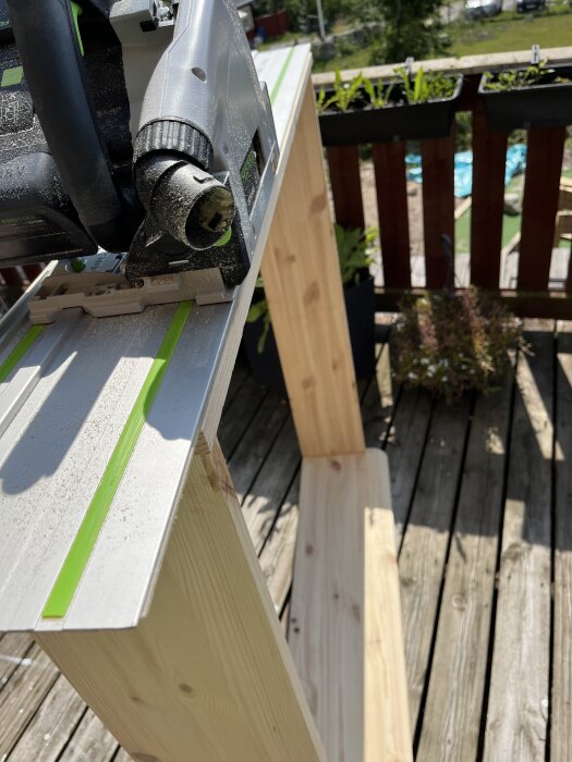 Cirkelsåg på en arbetsbänk i soligt väder, omgiven av träbjälkar.