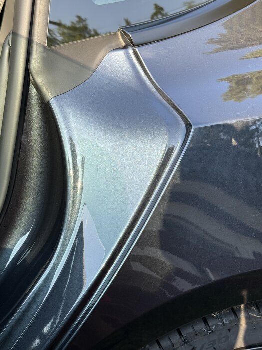 Bilens dörrgång med glänsande lack och reflektioner.