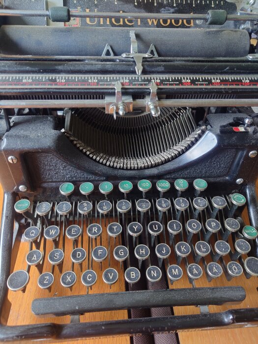 Gammal skrivmaskin med QWERTY-tangentbordet synligt, vilket visar traditionell design och nostalgi för mekanisk textbearbetning.