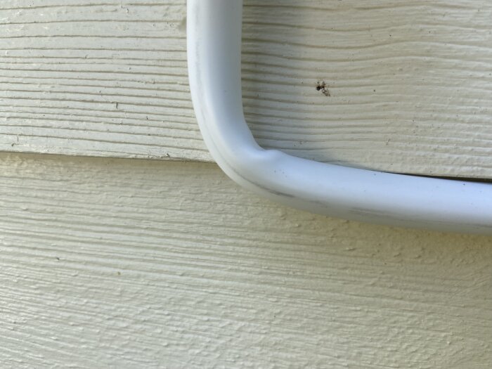 Kabel med skarp vinkel mot en ljus trävägg, en del av laddboxinstallation på landet.