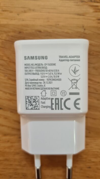 Samsung USB-laddare med specifikationer som visar utgång 5V/2A och 9V/1.67A, vit adapter med text på framsidan.
