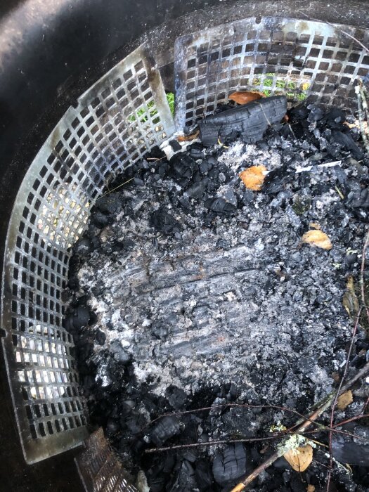 Eldstad av bilfälg och lastbilsfälg, med galler och aska.