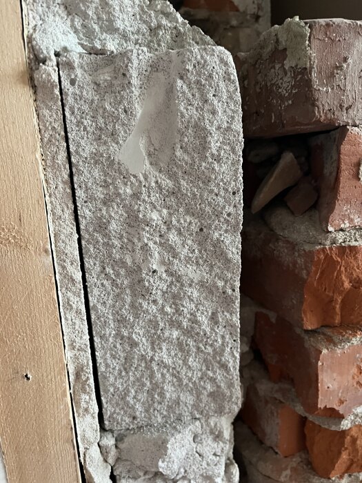 Grå byggsten bredvid tegelstenar, frågeställning om det är blåbetong.