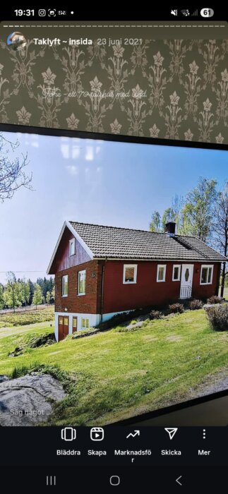 Rött hus med vita fönster och entré, beläget på en grönskande sluttning i lantlig miljö. Klarblå himmel och omgivande träd i bakgrunden.
