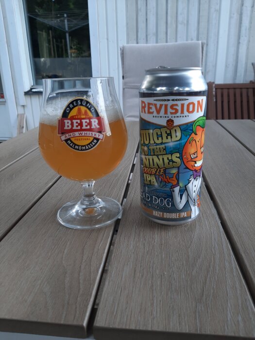 Ett glas hazy IPA från Öresund Beer & Whisky Festival och en burk Revision Brewing's "Juiced to the Nines" på ett trädäck.