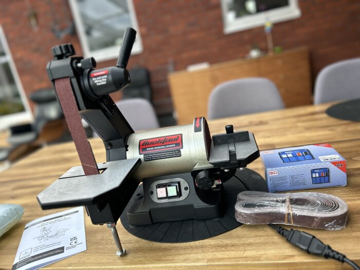 Slipmaskin med tillbehör och förpackning på träbord.