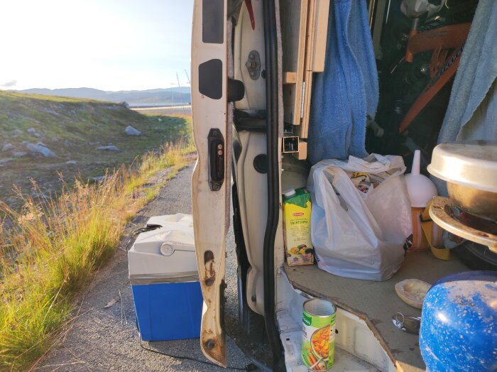 Öppen skåpbil med soppa och matvaror vid vägkant på fjället, solbelyst natur i bakgrunden.