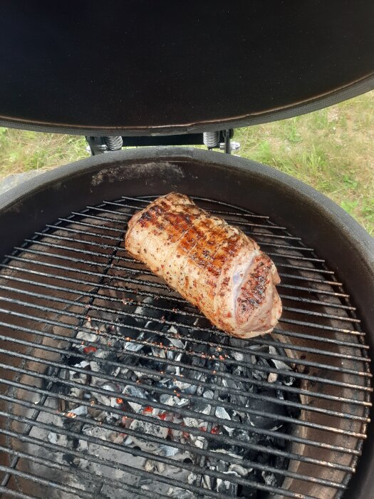 Grillad porchetta på en öppen kolgrill utomhus.