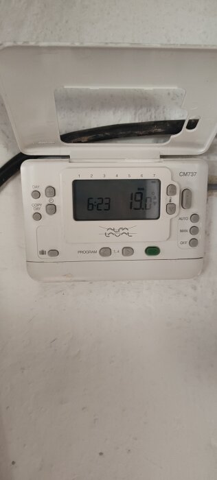 Termostatdisplay visar 6:23 och 19°C med knappar för inställningar och programmering.