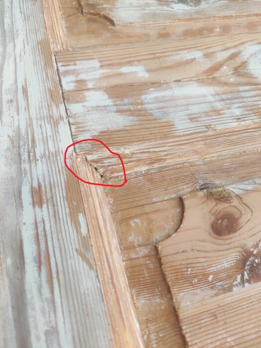 Gammal innerdörr med borttagen färg, markerad skarv mellan ram och fyllning som kräver åtgärd vid renovering.