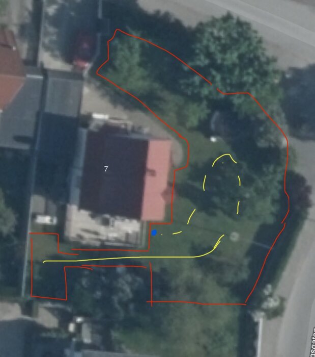 Flygbild av en tomt med en plan för guidekablar, markerade i gult. Startpunkten är en blå punkt nära mitten. Tomten har även röd inhägnad.