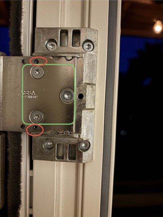 Närbild på ett gångjärn med sex skruvar, tre markerade i grönt och två i rött, för justering och åtdragning.