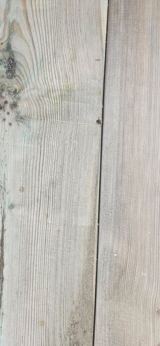 Närapå visad trall med dold skruvning, delar av skruvhuvud synligt mellan två plankor.