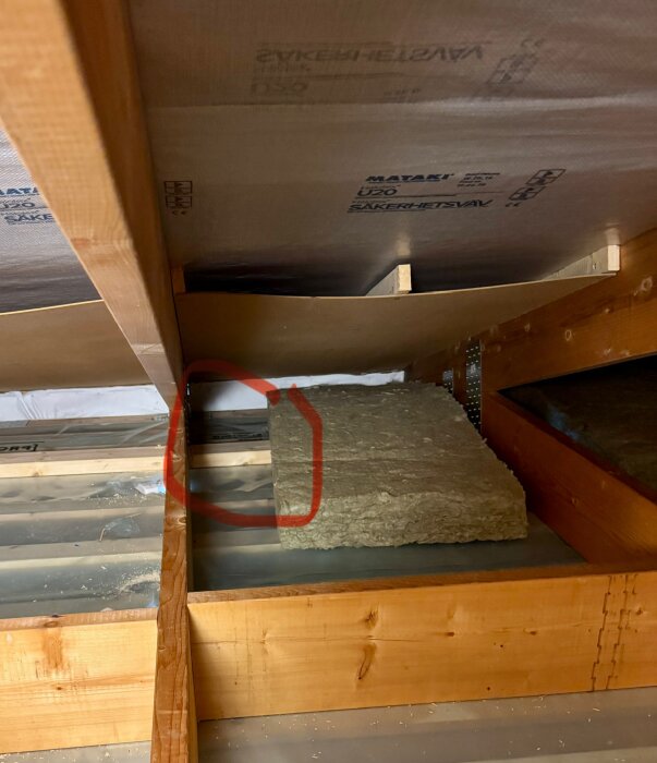 Vinttiä eristävä rakennusprojekti näytettää eristelevyn, puupalkin ja punaisen ympyrän kohdistuskohtaa katossa.