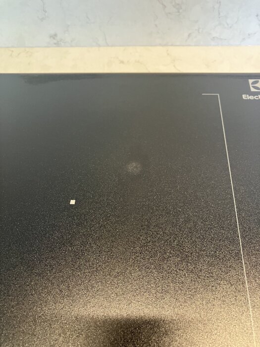 En induktionshäll med en synlig överhettad punkt på ytan.