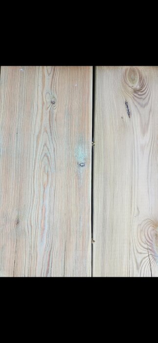 Två brädor med olika träådring och färgnyans ligger intill varandra.