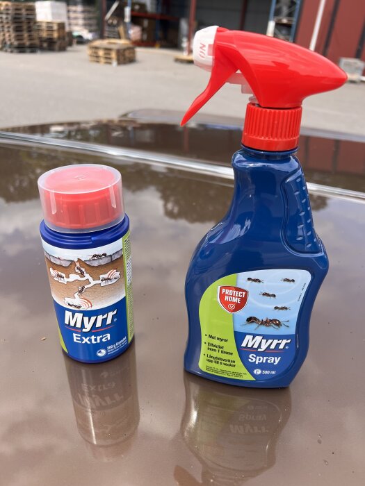 Två Myrr-produkter, en burk och en sprayflaska, står på en yta. Båda används för att bekämpa myror.