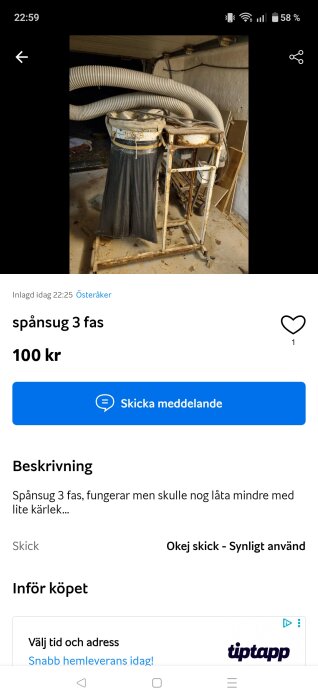 Spånsug med flera stora vita slangar i ett garage, stående på hjul och delvis täckt med en svart sopsäck.