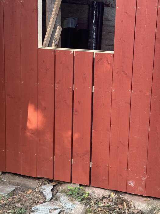 Röd träpanel på 1800-talshus med varierande mellanrum mellan brädorna.