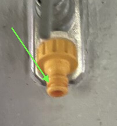 Gul anslutning utan o-ring, markerad med en grön pil, som kan orsaka läckage om tätningen är trasig eller saknas.
