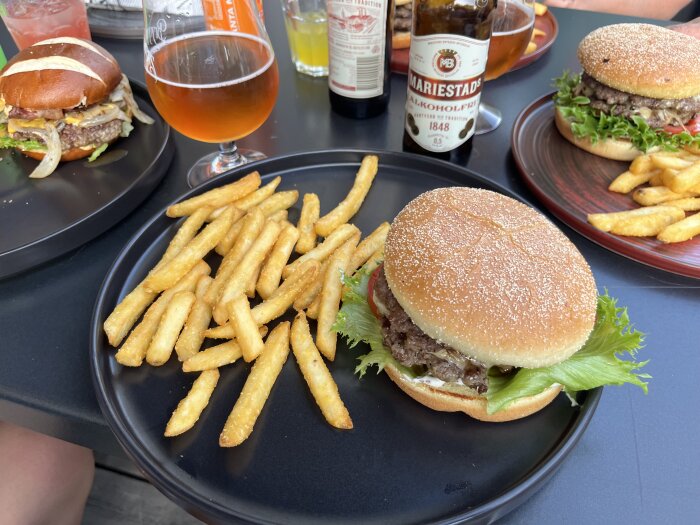 Tryffelburgare med pommes frites och öl på en tallrik.