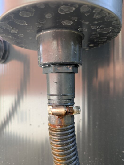 Korrosion och fuktfläckar på en metallrörskoppling på pool. Ringen är åtdragen för att förhindra läckage.