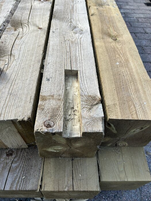 Trähög med en 150x150 mm stolpe som har ett urtag längs en kant, placerad på markstenar.