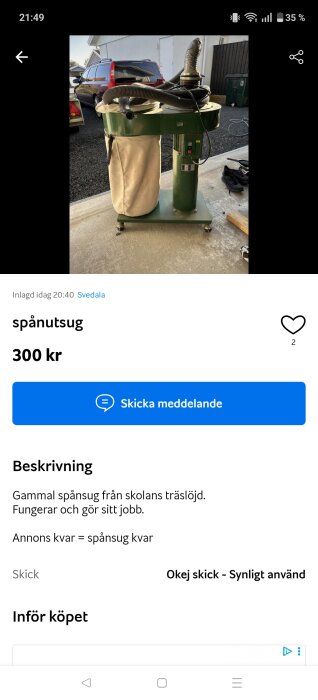 Gammal spånsug med slangar och säck på hjul, fotograferad utomhus på asfalt.