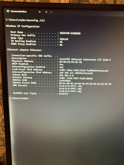 Skärmbild av kommandotolken som visar resultatet av "ipconfig /all" med detaljer om nätverkskonfiguration, inklusive IP-adresser och adapterinformation.