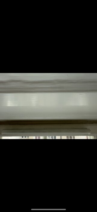 Ventilationsöppning utan synlig stängningsmekanism, inomhusdel av ventil mot ljus bakgrund.