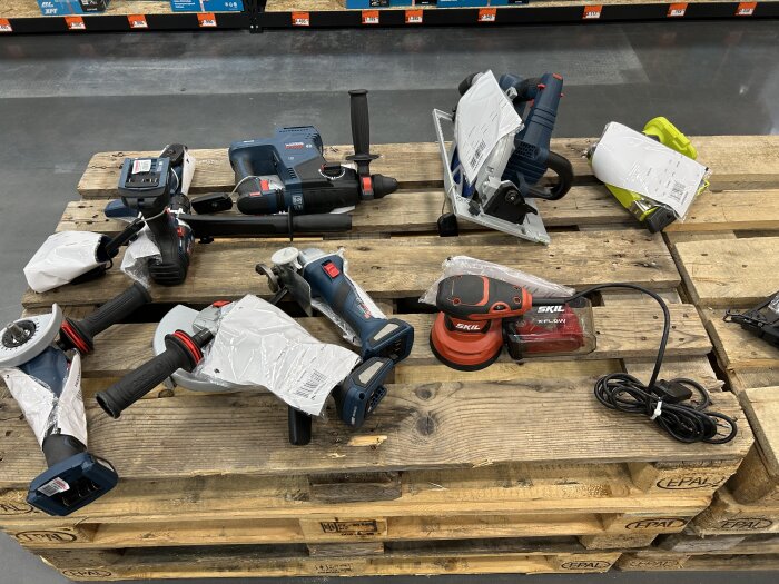 Verktyg från Bauhaus, inklusive GKS 18V, ligger på lastpallar i butik.
