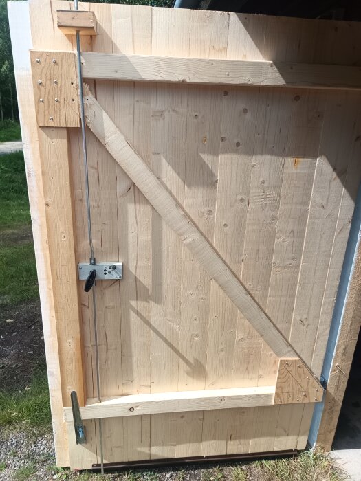 Trägarageport med inslag av egen låslösning i dagsljus.